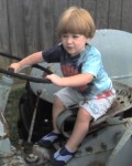 062207 Benjamin Grey Mesko in the backyard on the tractor - Fairfield VA